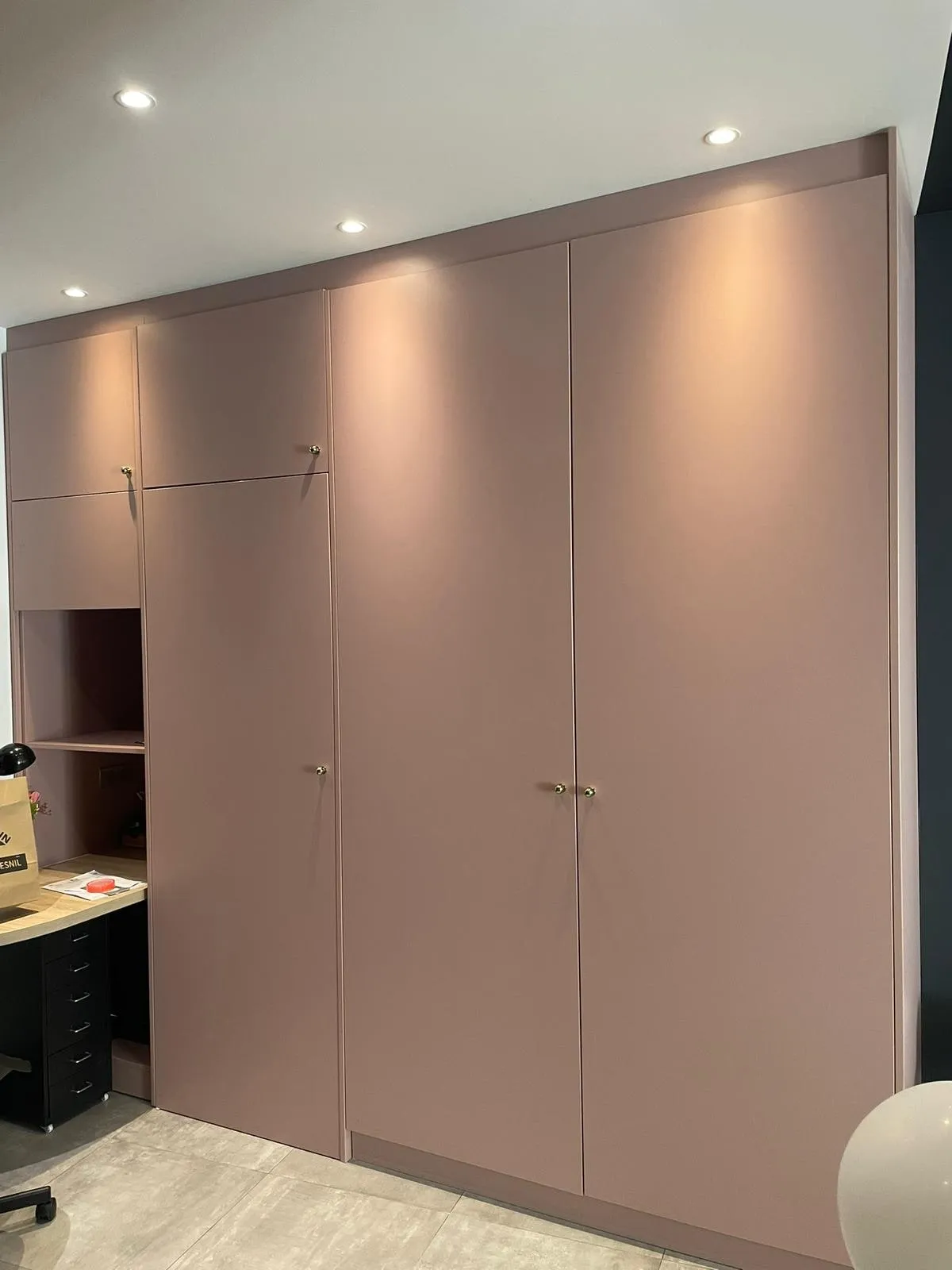 Dressing vieux rose toute hauteur à portes lisses et boutons laiton, retour bureau et caisson noir à gauche