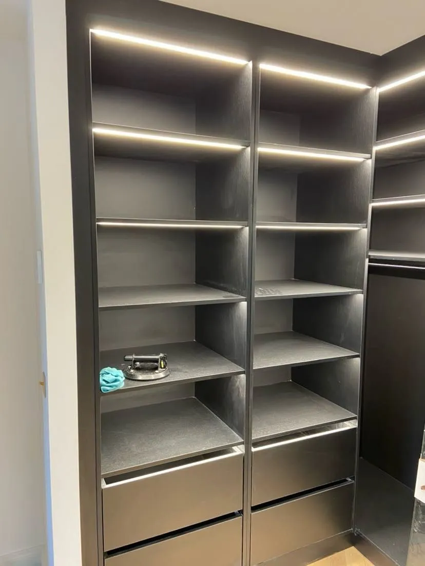 Colonne de dressing noire avec cinq tablettes LED et tiroirs a prise de main intégrée