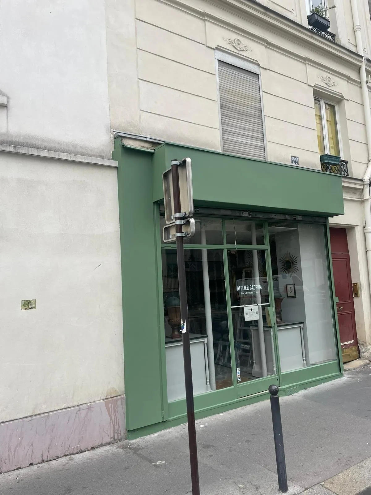 Devanture de commerce peinte en vert avec bandeau plein et vitrine toute hauteur, immeuble haussmannien