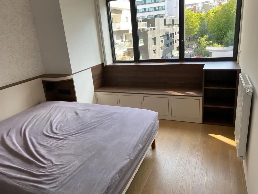 Banquette de fenêtre en noyer avec coffres beiges, tete de lit et étagère d'angle assortie