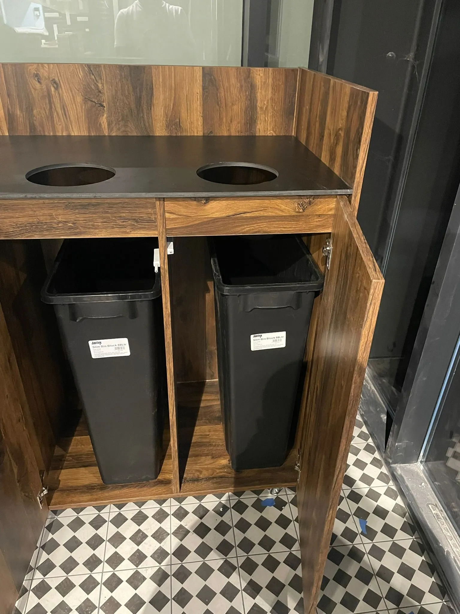 Meuble poubelle double en stratifié noyer, plan noir perce de deux tremies, porte ouverte