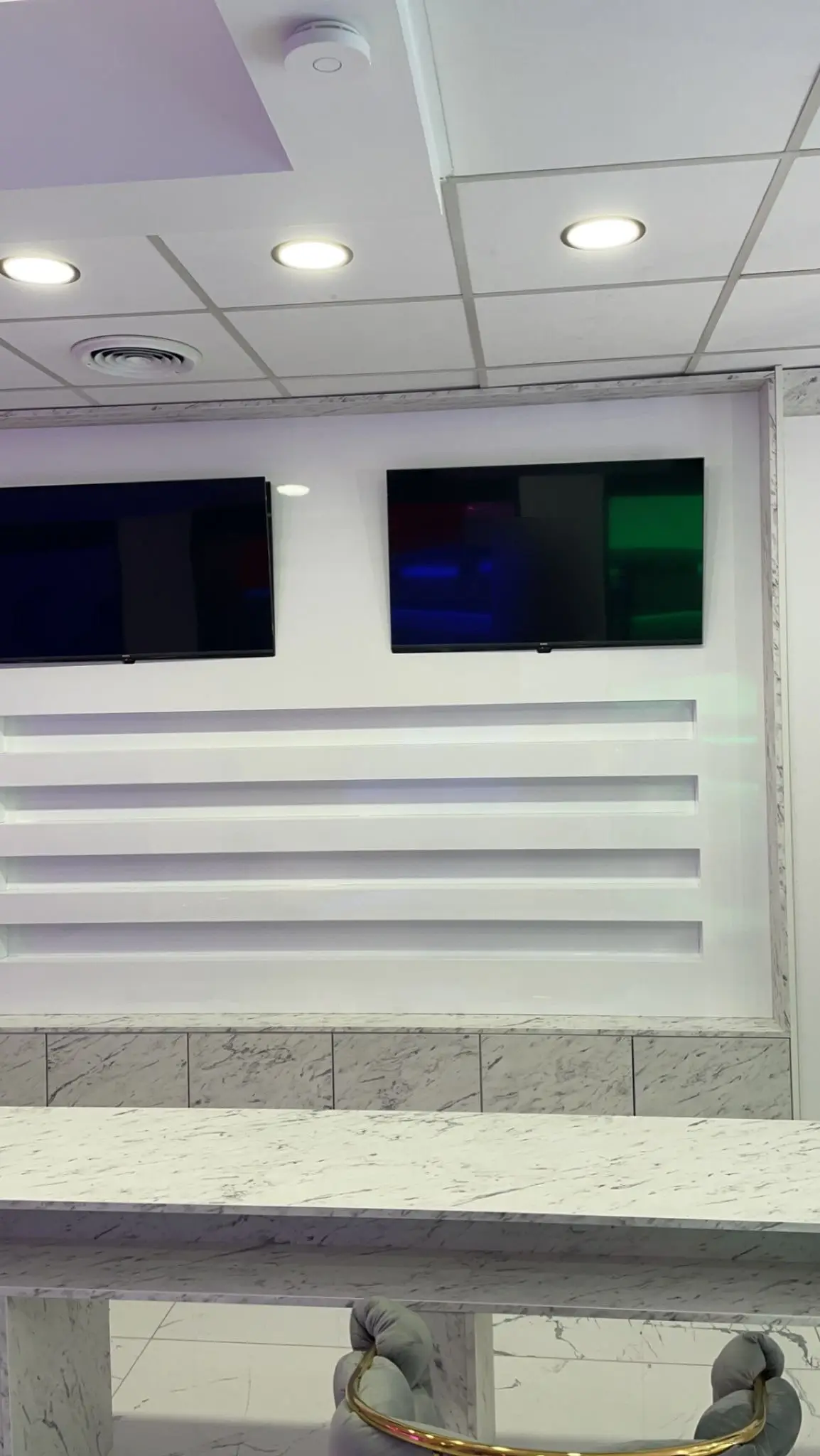 Mur de présentation avec quatre étagères laquées blanches rétroéclairées et deux écrans